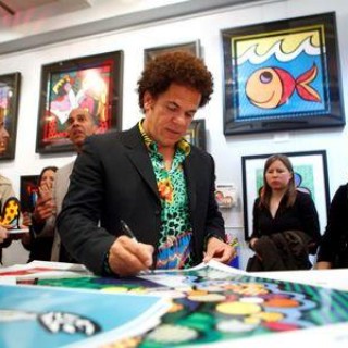 Artist Romero Britto signs posters at a gallery in New York